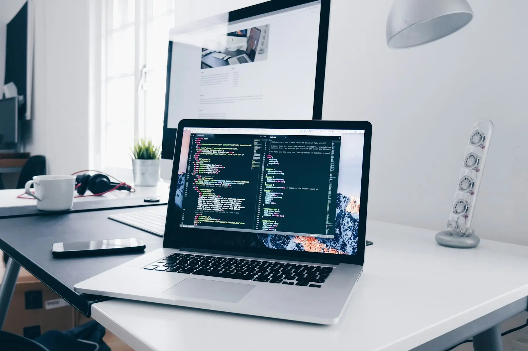 Laptop on a bright desk showing website code